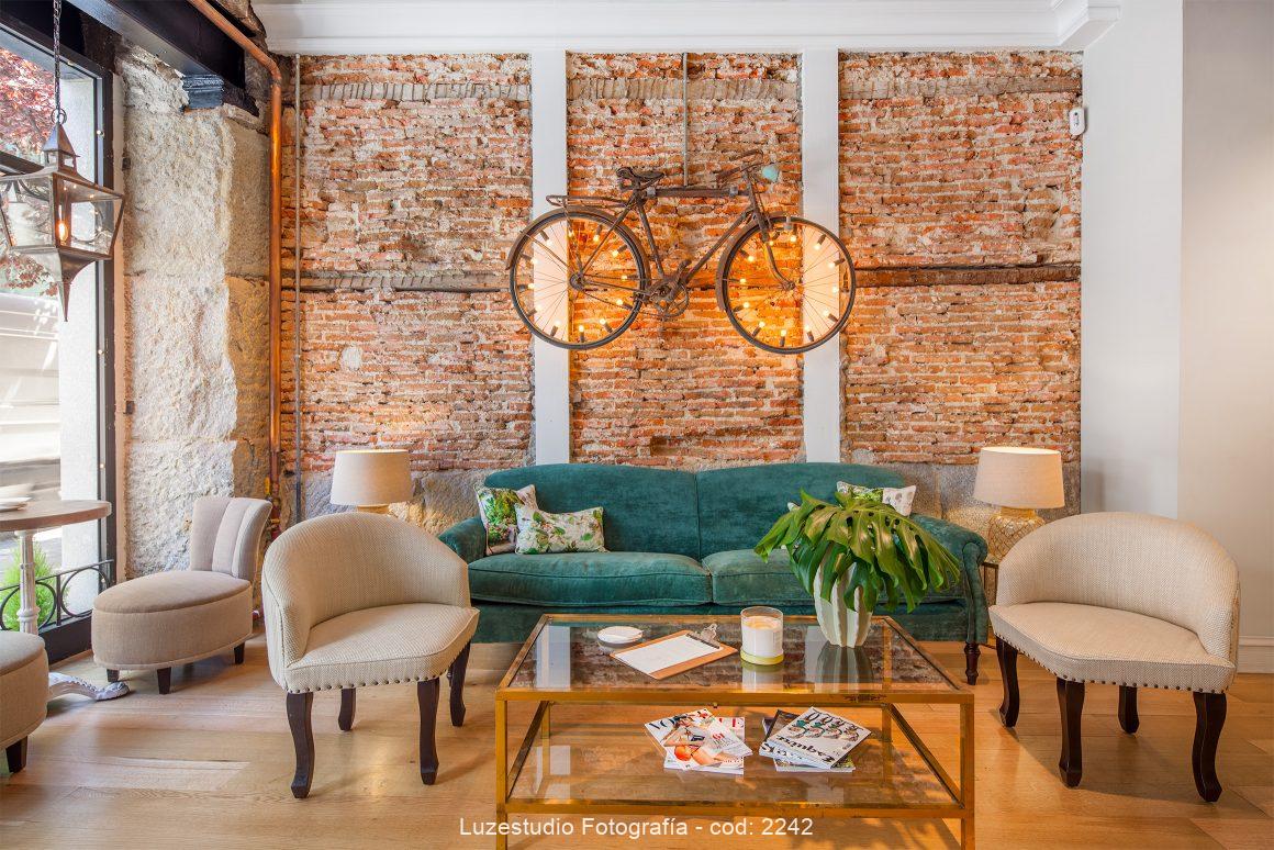 fotografía de arquitectura interior restaurante la jefa madrid con pared de ladrillo decoración bicicleta vintage sofa verde diseño marta auyanet