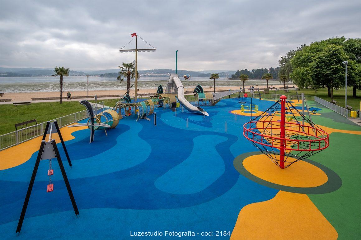 fotografía elevada parque infantil con suelo de colores frente a playa en sada galicia