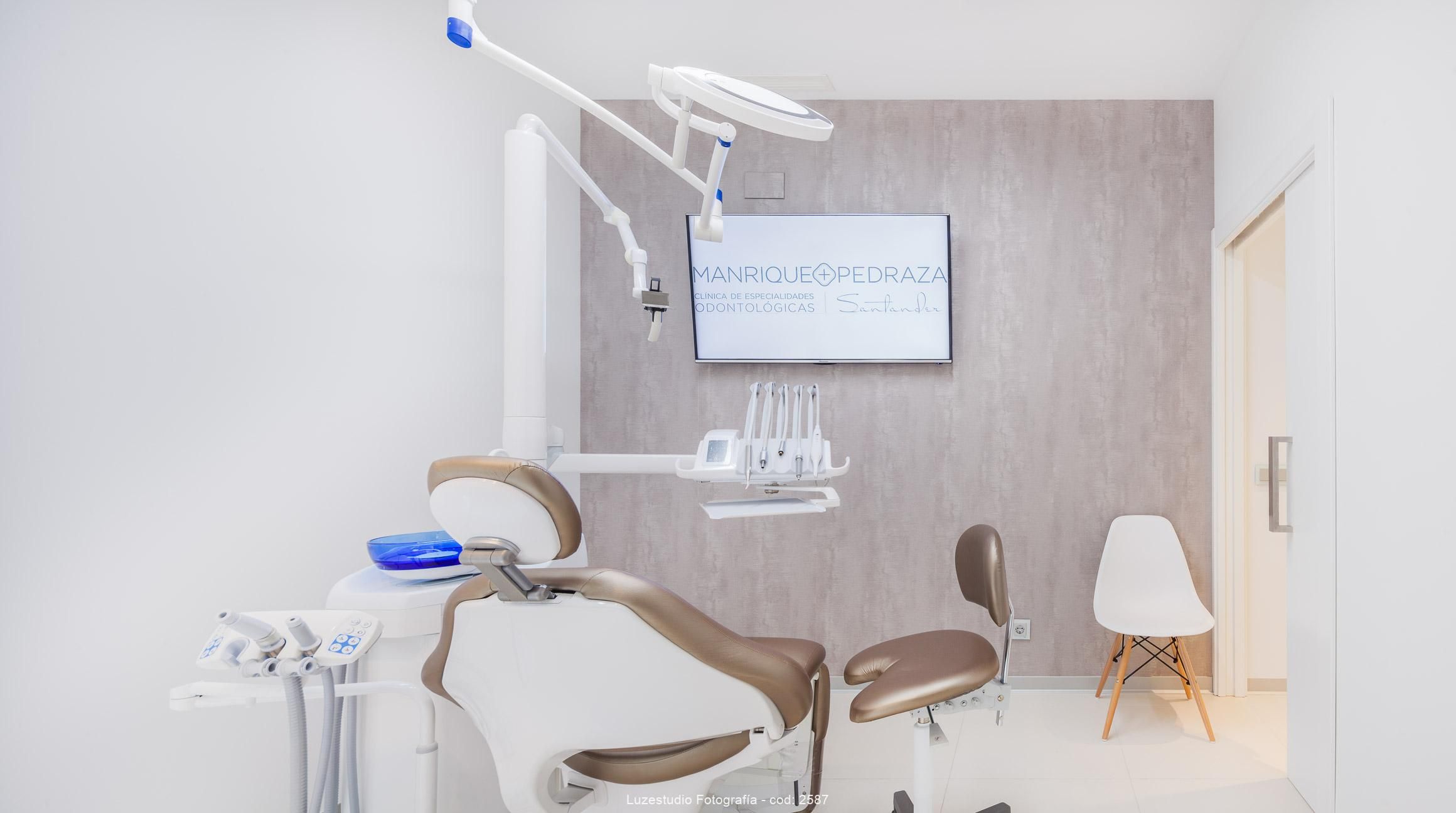 gabinete con camilla dentista y pantalla en clinica dental santander