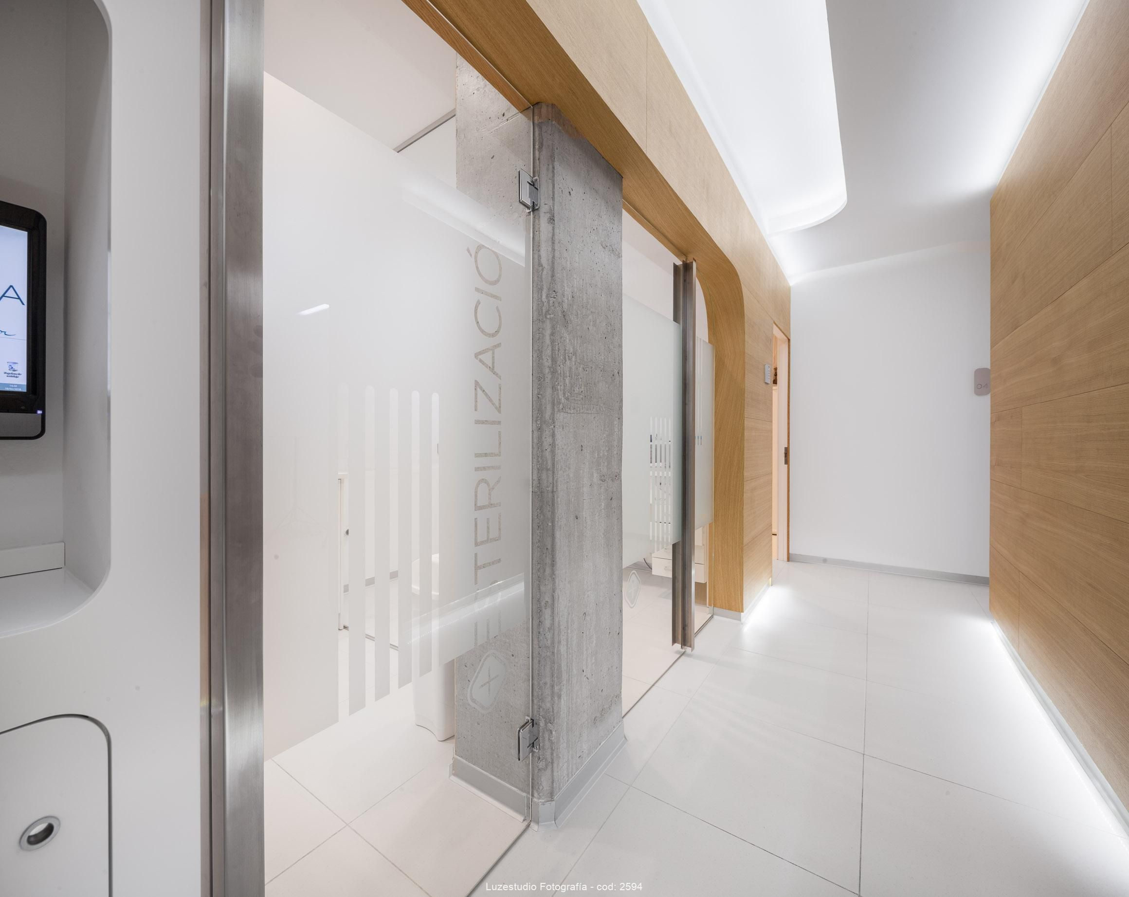 pasillo en clinica dental con pared de madera y puertas acristaladas con vinilo en santander
