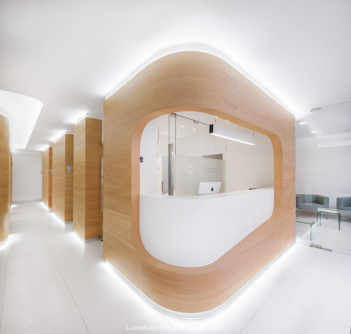 foto de diseño de interiores en clinica dental con madera y led zona recepción