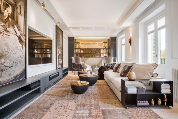 salon de lujo con sofa color crema, muebles de salón y barra al fondo en un piso del paseo de la castellana fotografiado por fotógrafo de interiores en Madrid