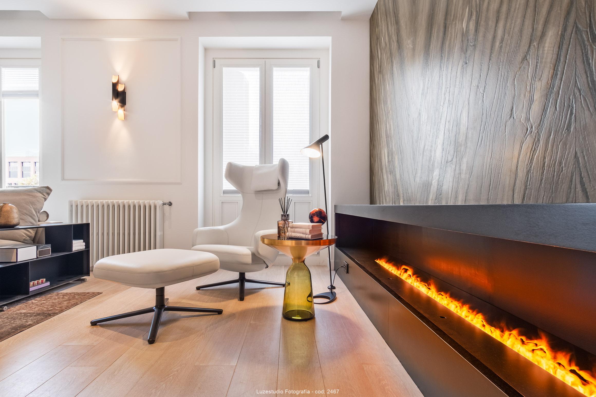 interior de vivienda de lujo con chimenea encendida y mesita con libros