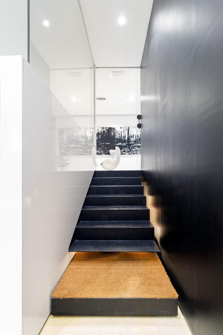 escalera de metal con silla blanca y cuadro al fondo