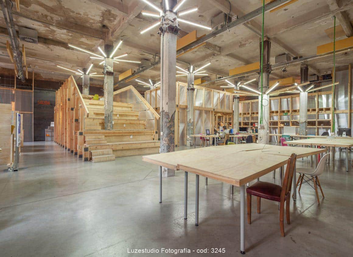 espacio abierto con auditorio en forma de escaleras y mesas de madera en factoria cultural