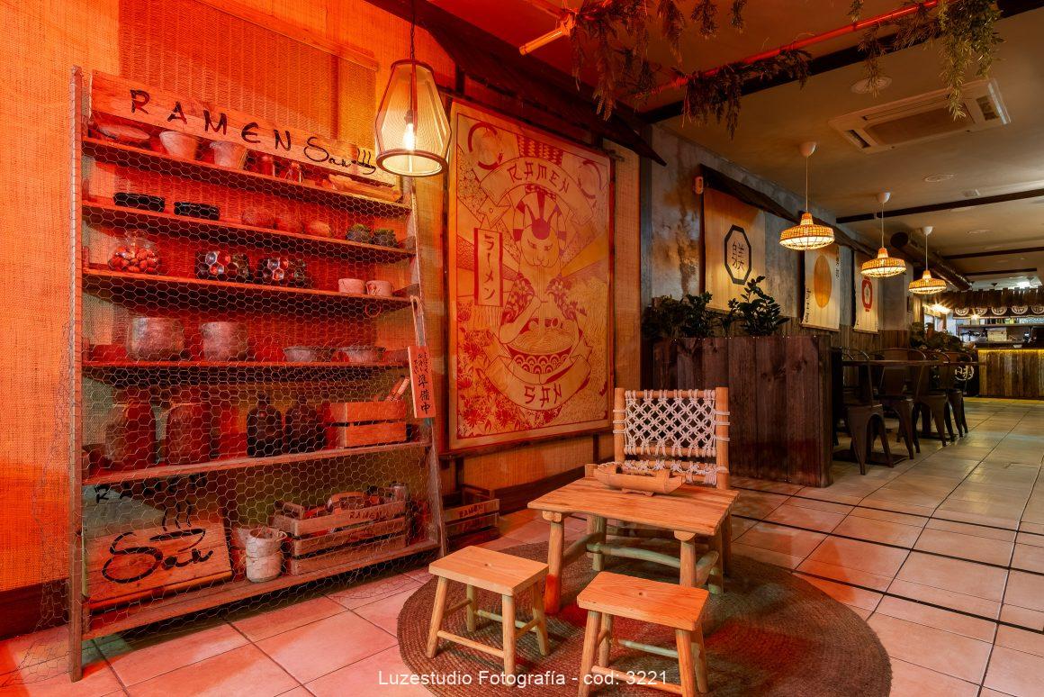 fotografía de interior del diseño de ramen san zona de entrada con estantería y muebles tipicos japoneses