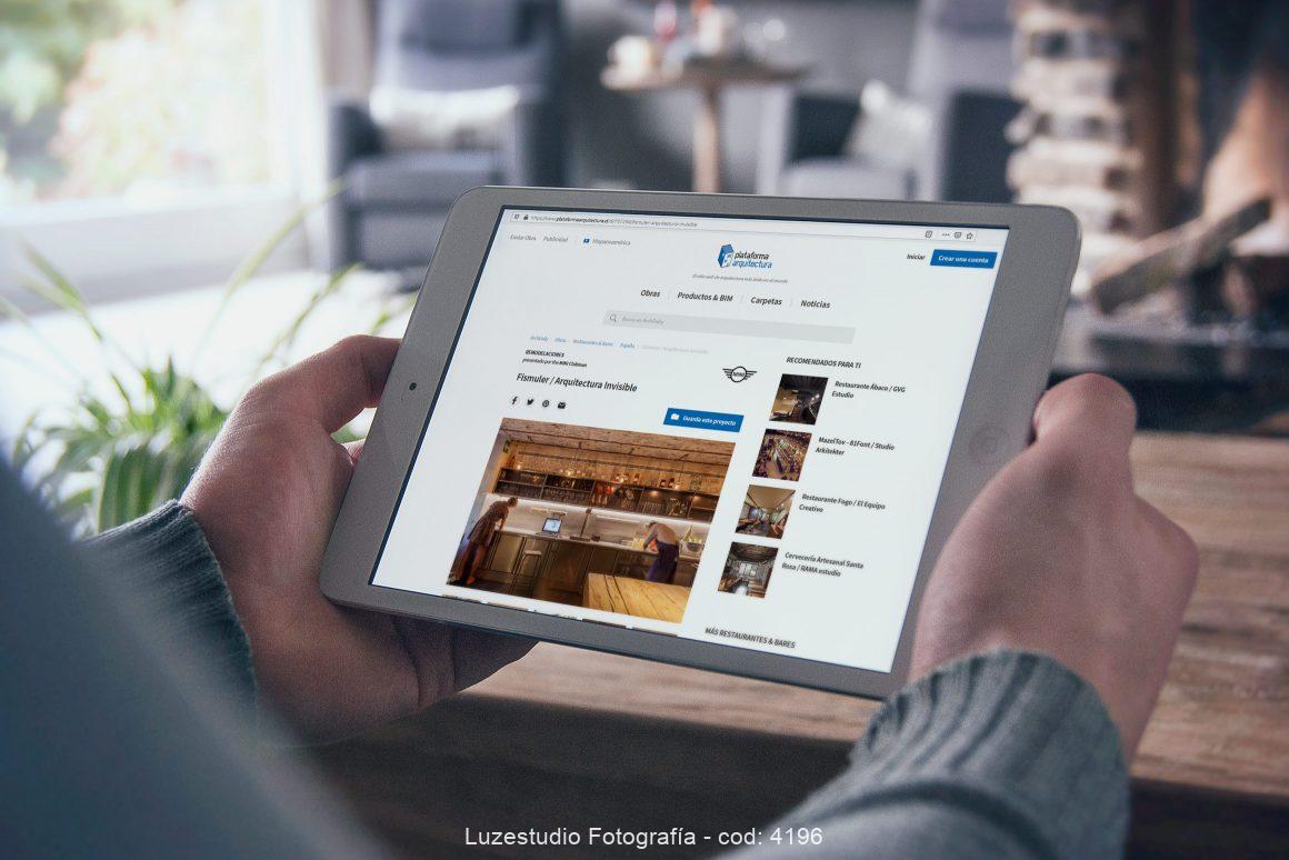 hombre sujetando ipad con fotografía de luzestudio publicada en plataforma arquitectura