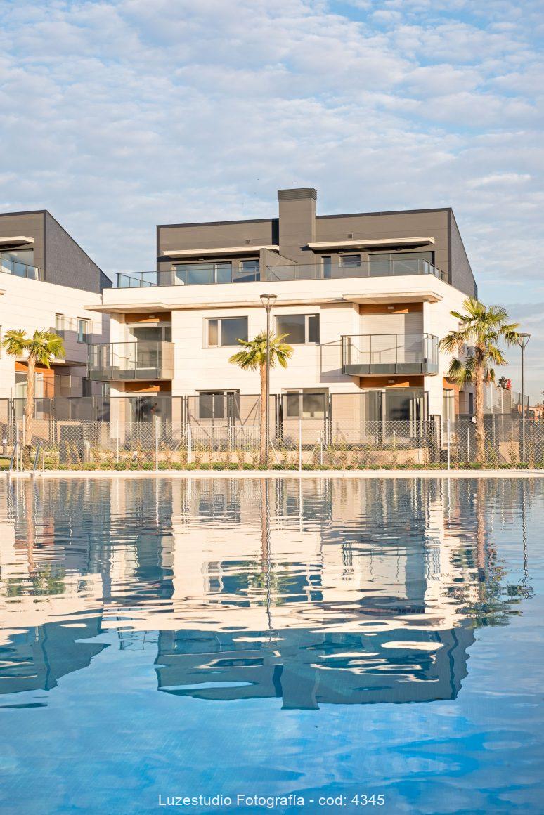 chalet pareado frente a piscina con palmeras en boadilla del monte