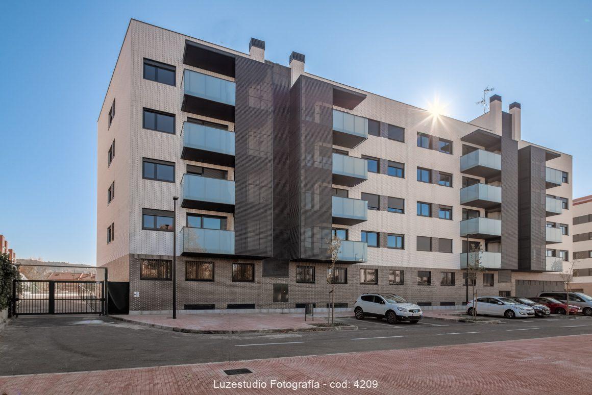 arquitectura edificio de viviendas con puerta de accceso y plazas de parking