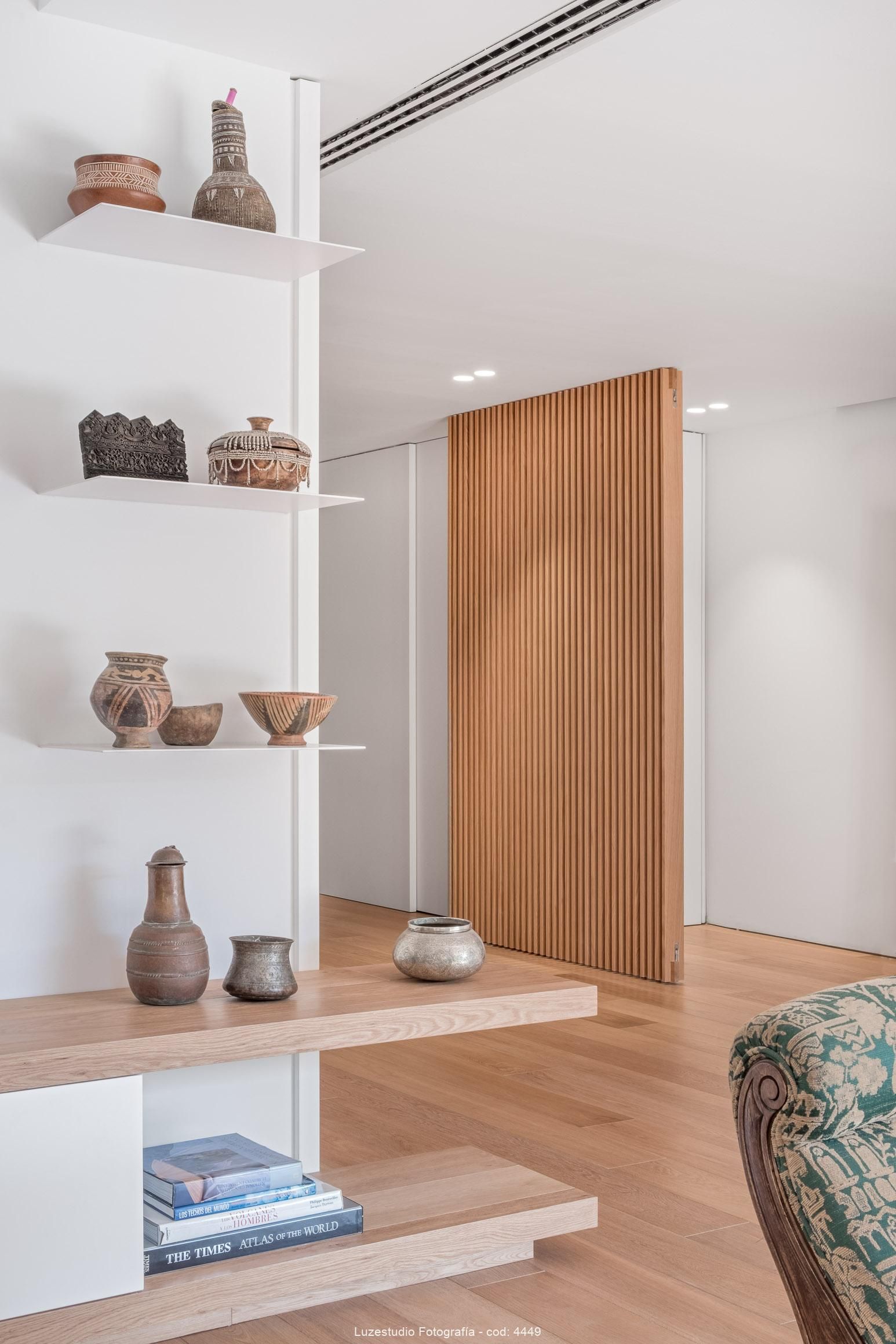 estanterias con ceramica y libros en salón con suelo de tarimas de autor