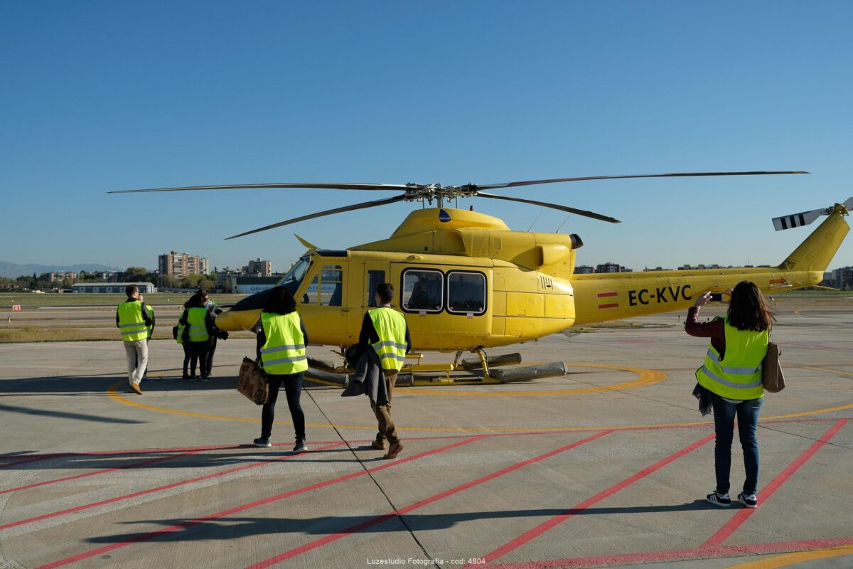 helicoptero amarillo rodeado por gente con chaleco reflectante en el aeropuerto cuatro vientos madrid