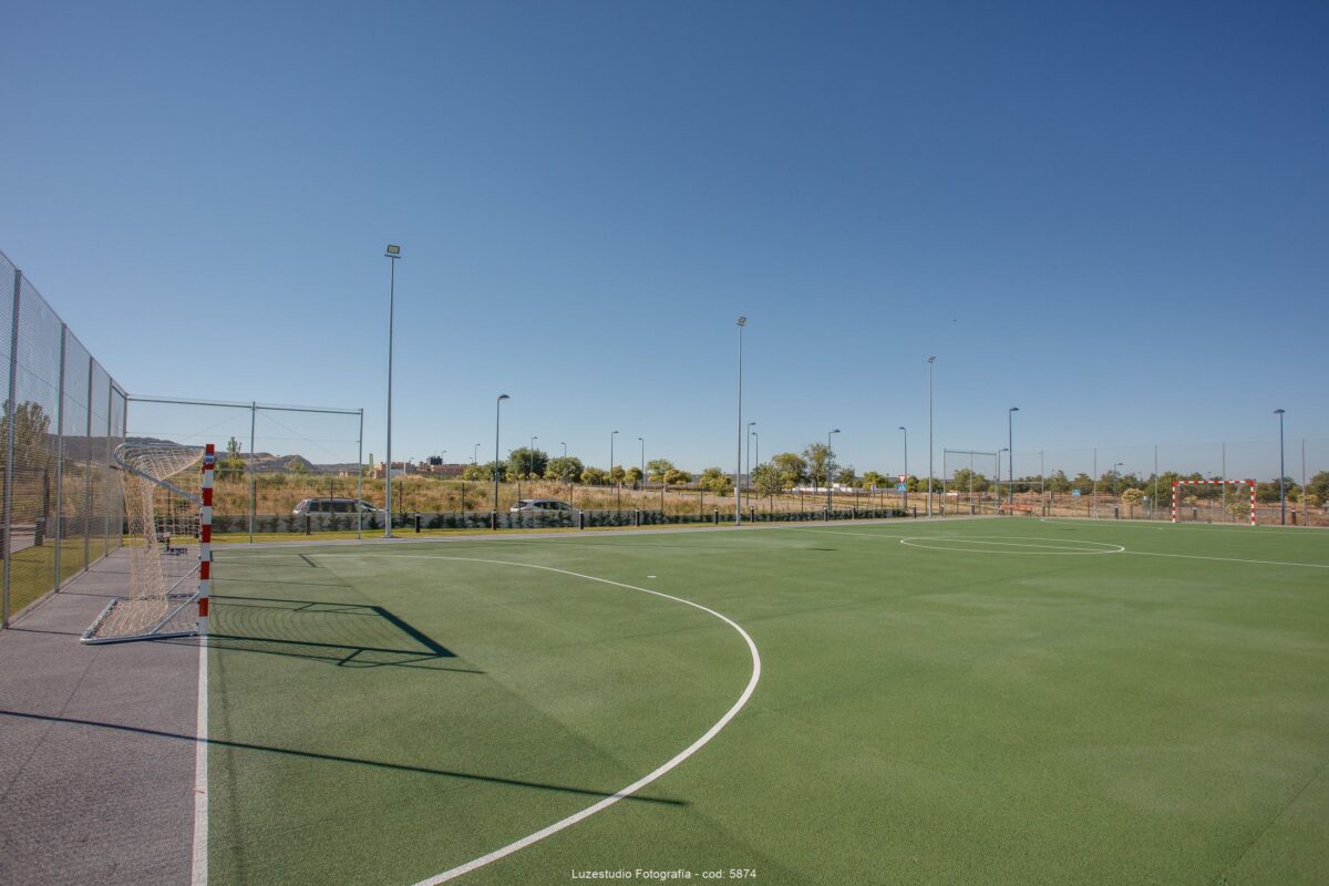 campo de futbol con terreno artificial e iluminación nocturna en urbanización de la comunidad de madrid