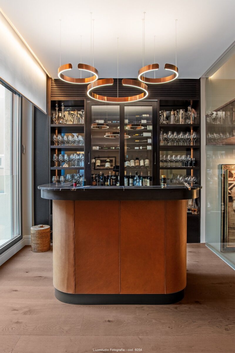 fotografía de interiores bar de diseño con lamparas con led y vitrina con botellas y copas