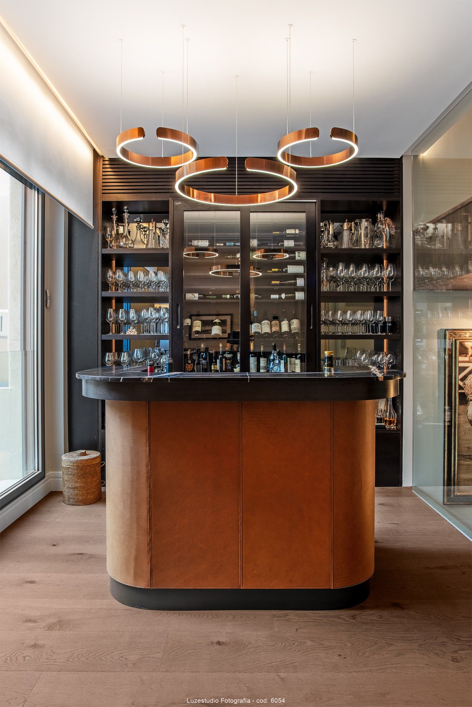 fotografía de interiores bar de diseño con lamparas con led y vitrina con botellas y copas