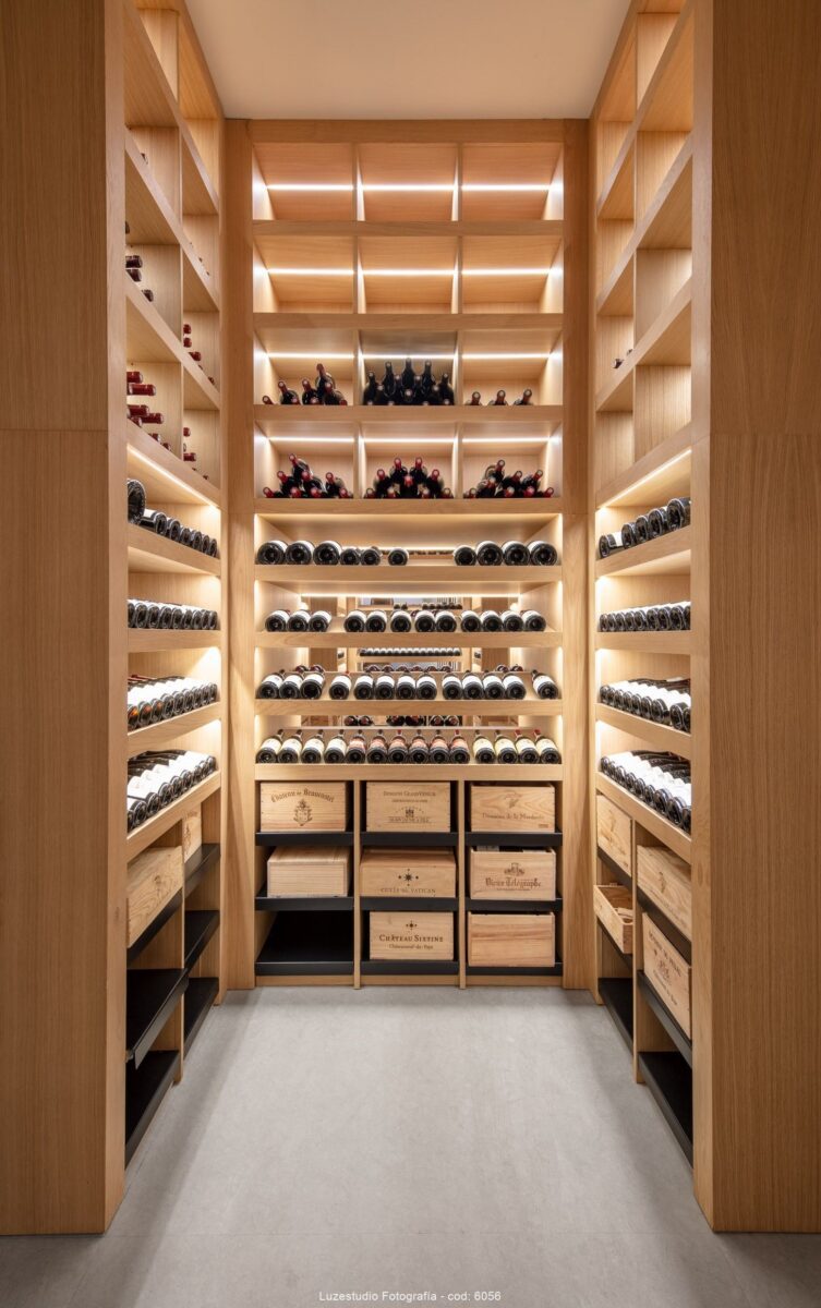 fotografía de interior bodega con cajas de vino y botellas ordenadas en estanterias a medida