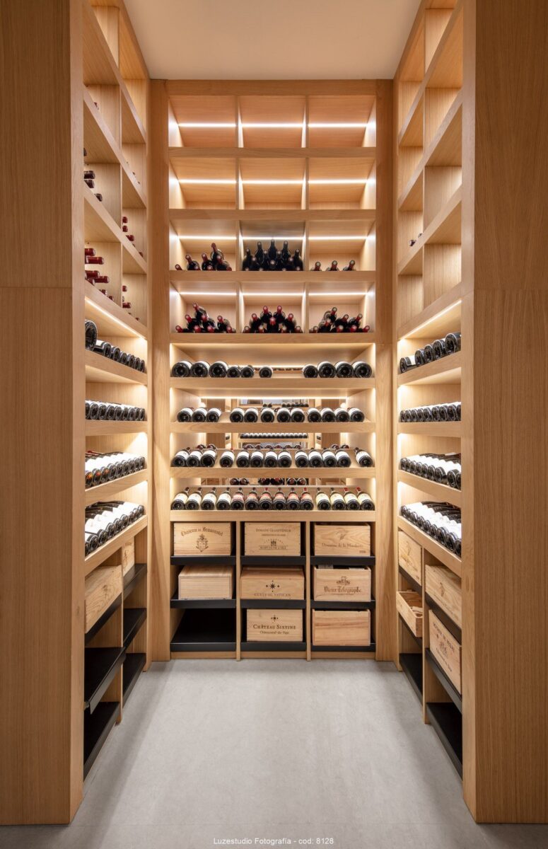 bodega privada con estanterias de suelo a techo con iluminción led y botellas de vino