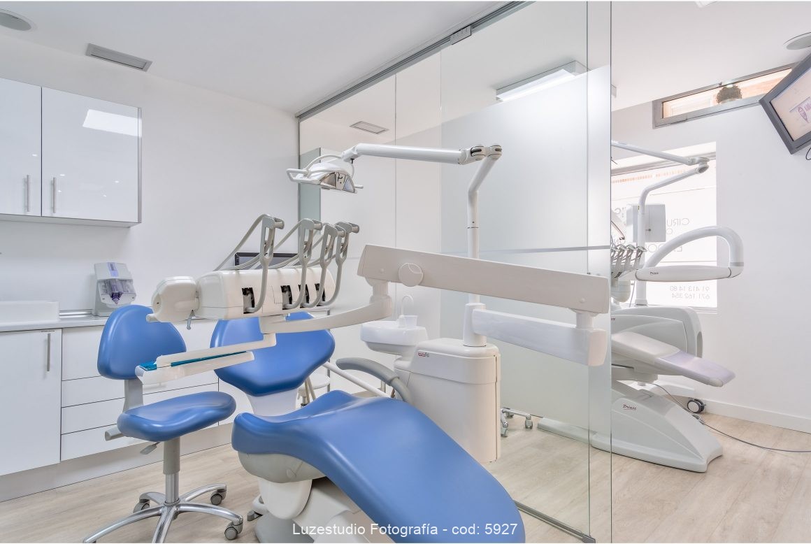 gabinete dentista con mobiliario sanitario con silla azul y puerta deslizante de cristal vinilado