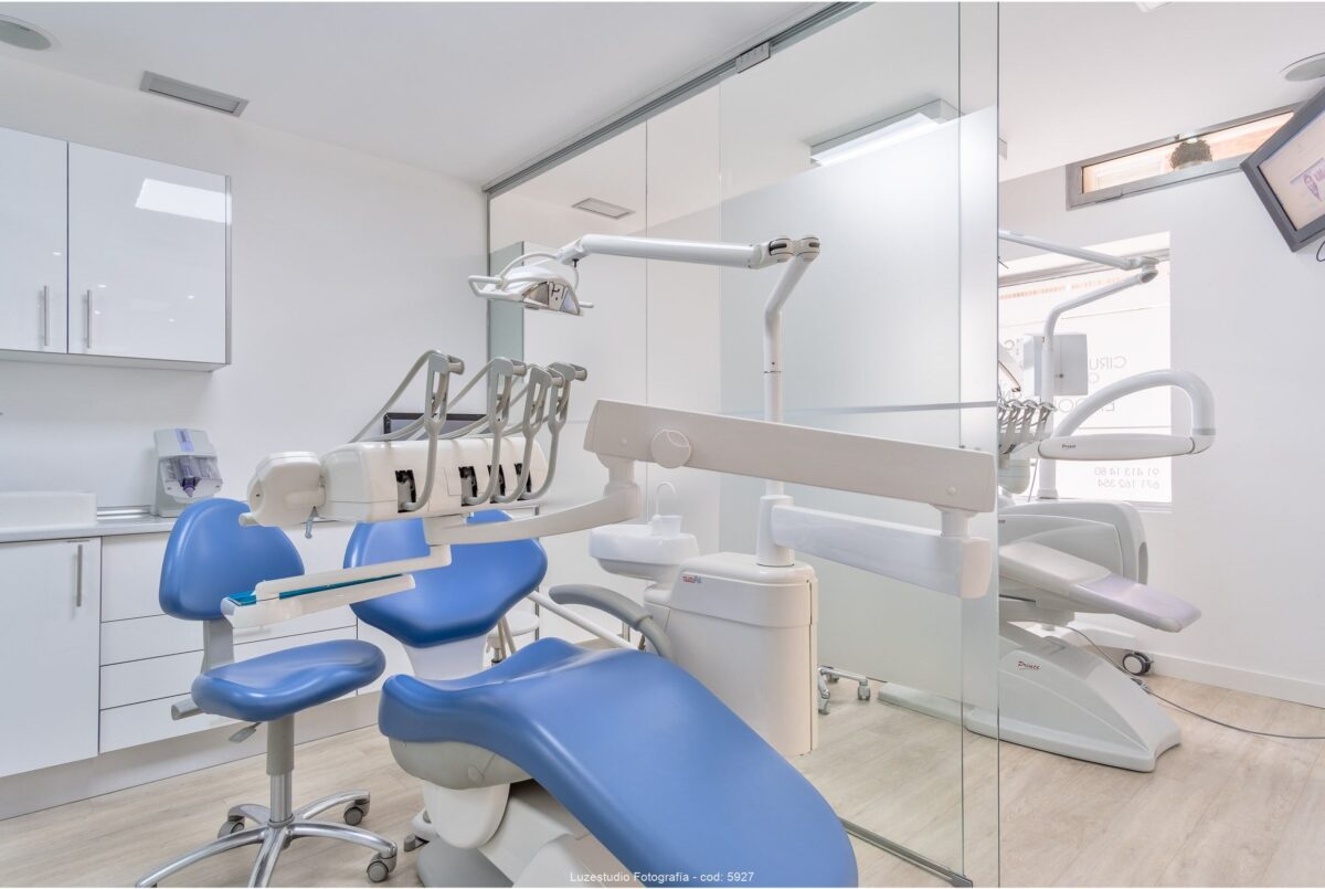 gabinete dentista con mobiliario sanitario con silla azul y puerta deslizante de cristal vinilado en serie de fotografia de diseno sanitario
