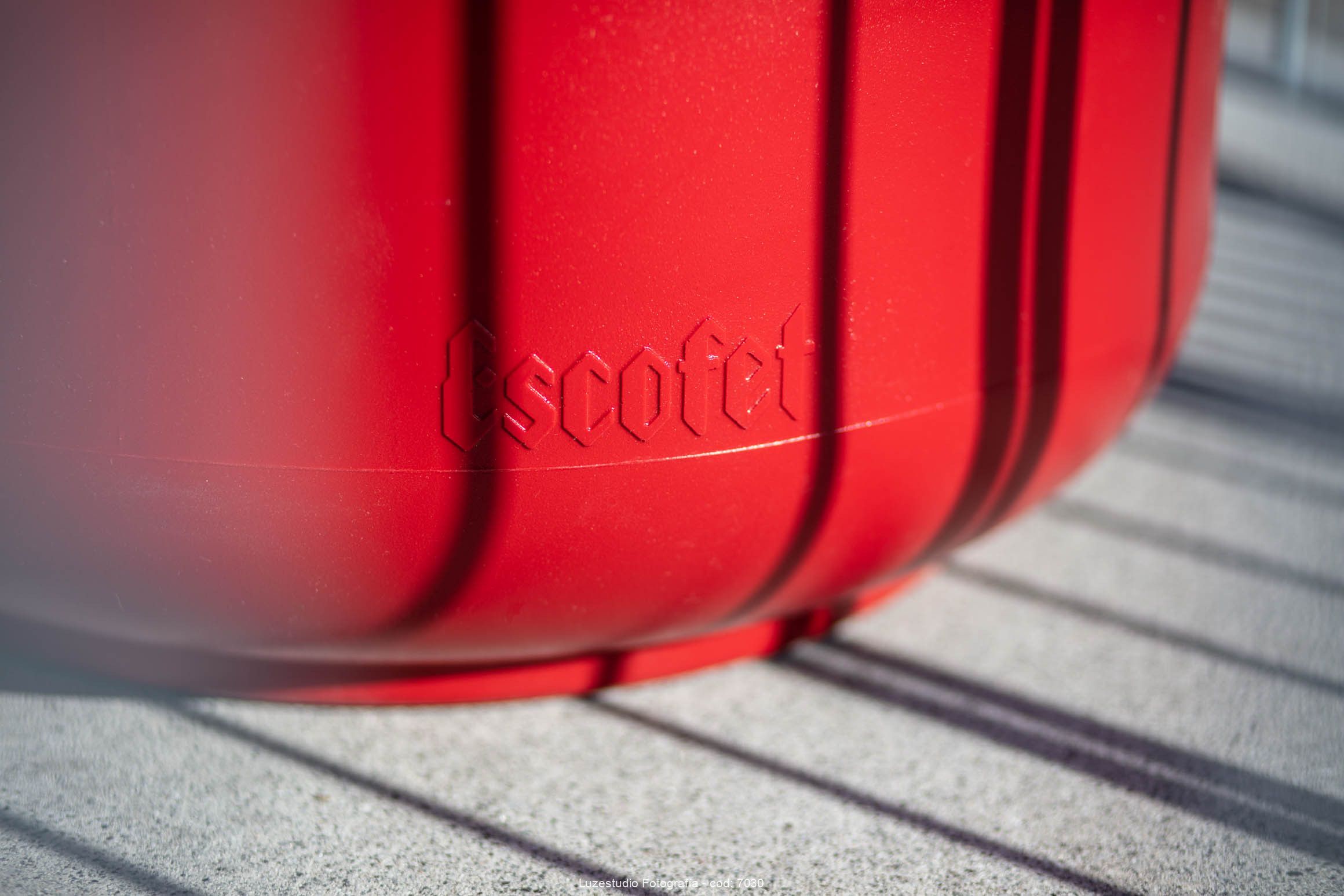 detalle del nombre escofet en el taburete stul de color rojo con luz natural y sombra
