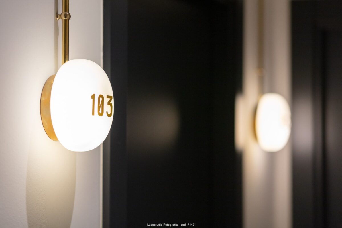 luminaria con número de habitación retroiluminado en pasillo de hotel