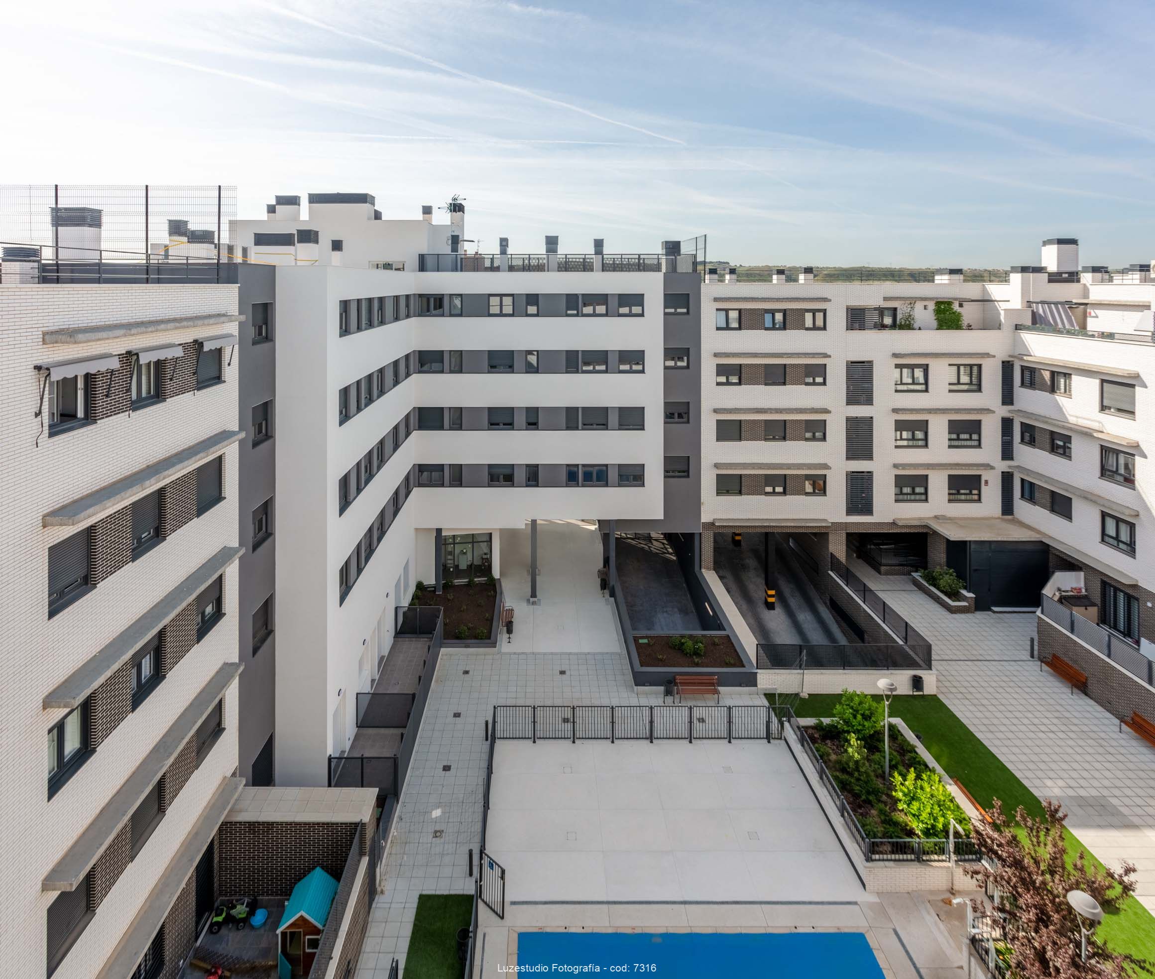 fotografía de arquitectura edificio de viviendas con patio interior con entrada de garaje