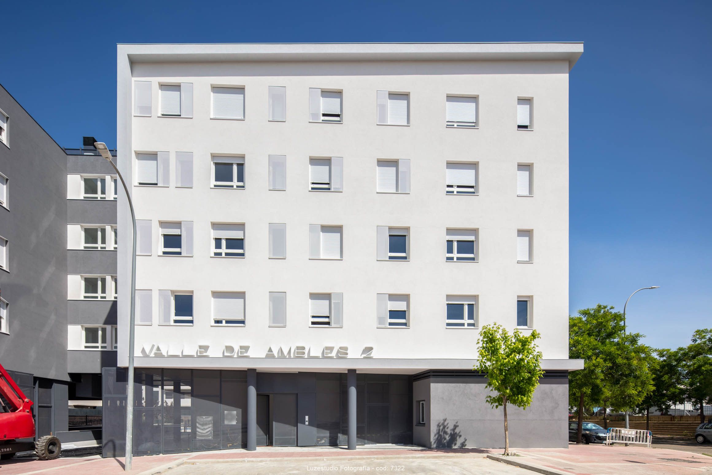 fachada principal de edificio de viviendas en día con cielo azul fotogarfiada por fotógrafo de arquitectura