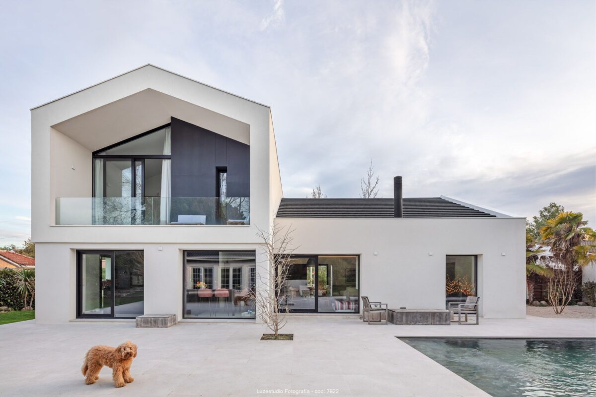 foto de arquitectura casa unifamiliar con fachada blanca amplias ventanas y perro barbet marron en pozuelo