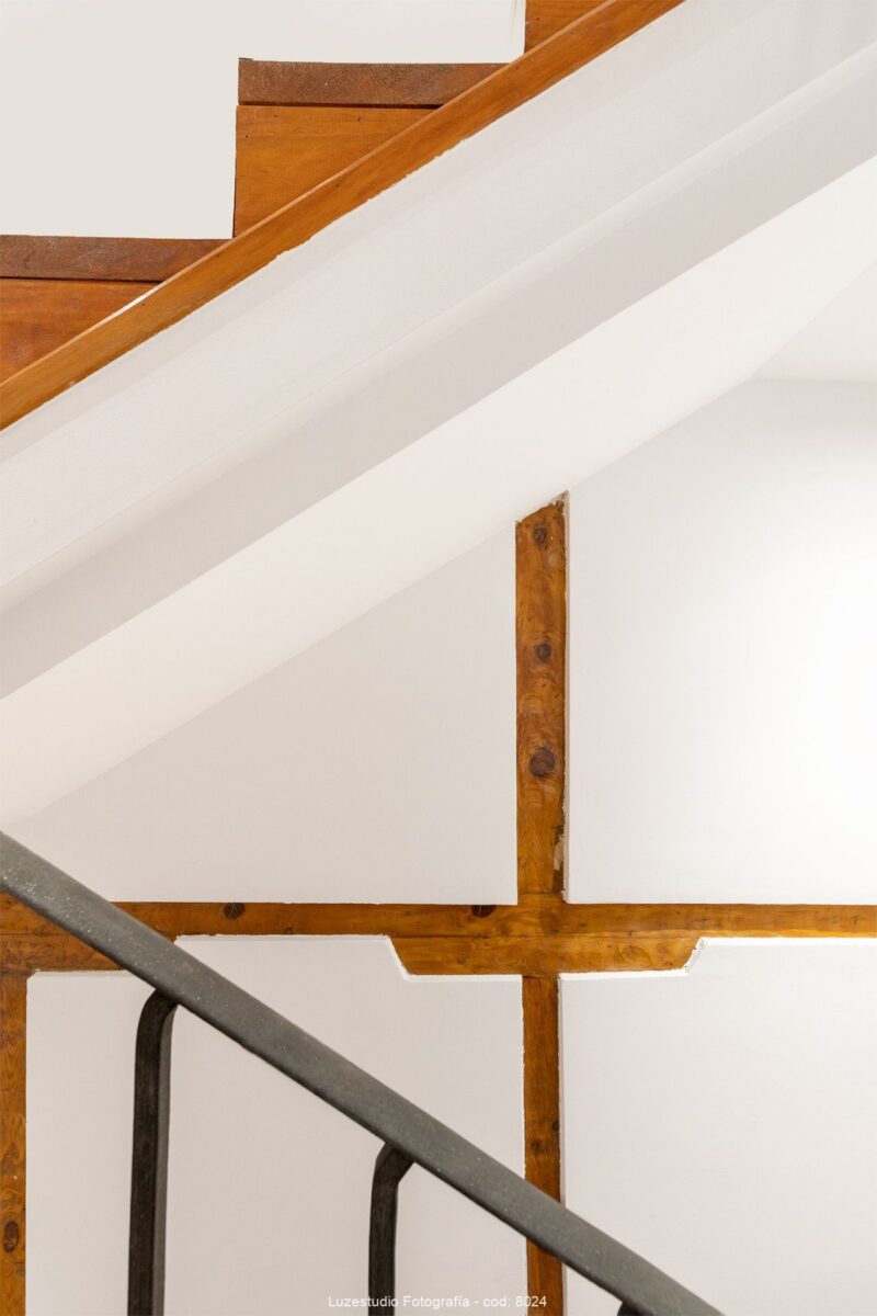 fotografía minimalista de arquitectura con escaleras de madera y vigas antiguas a la vista