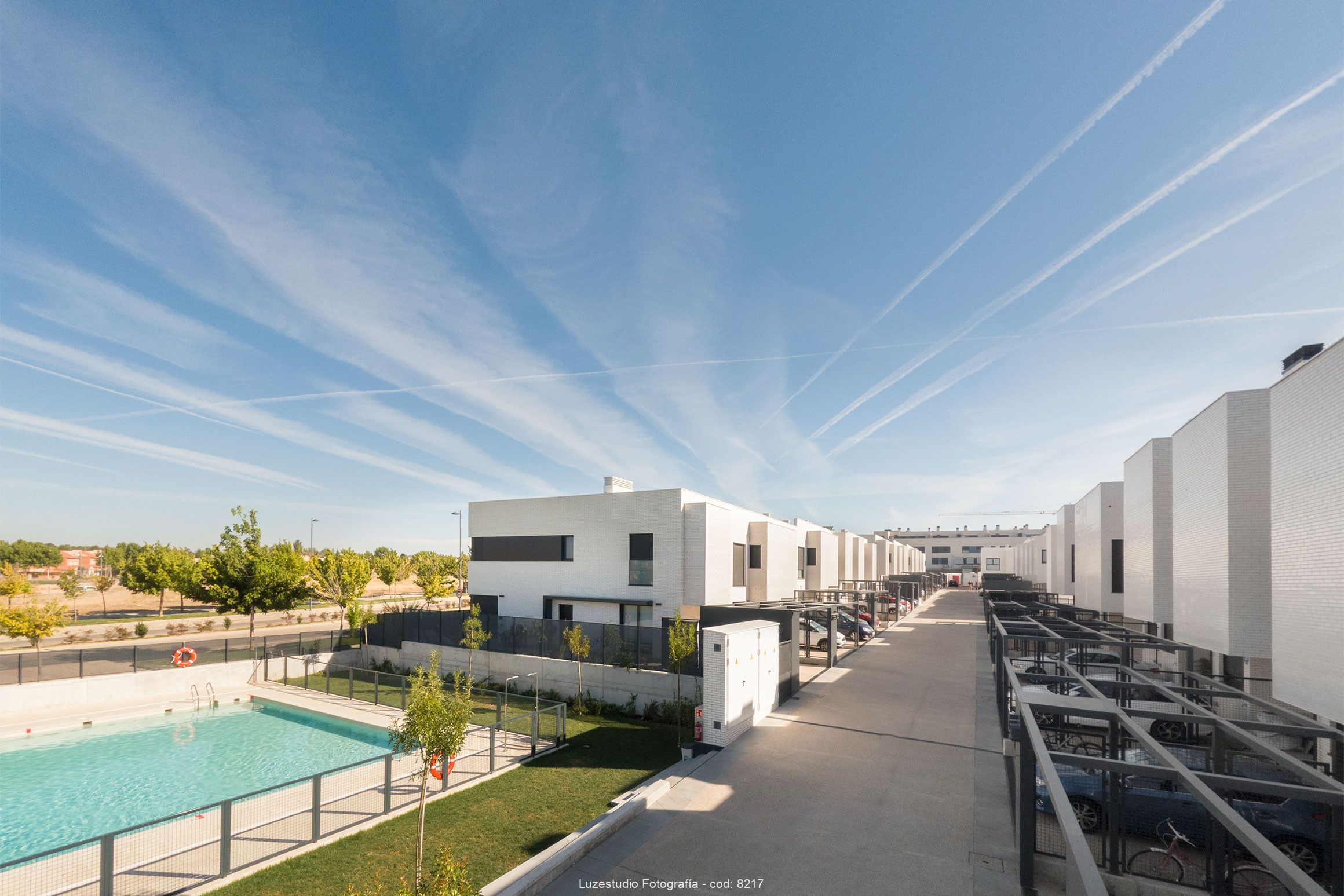 fotografía aerea elevada de urbanizacion con chalets pareados con aparcamiento y piscina con zonas verdes en la comunidad de madrid