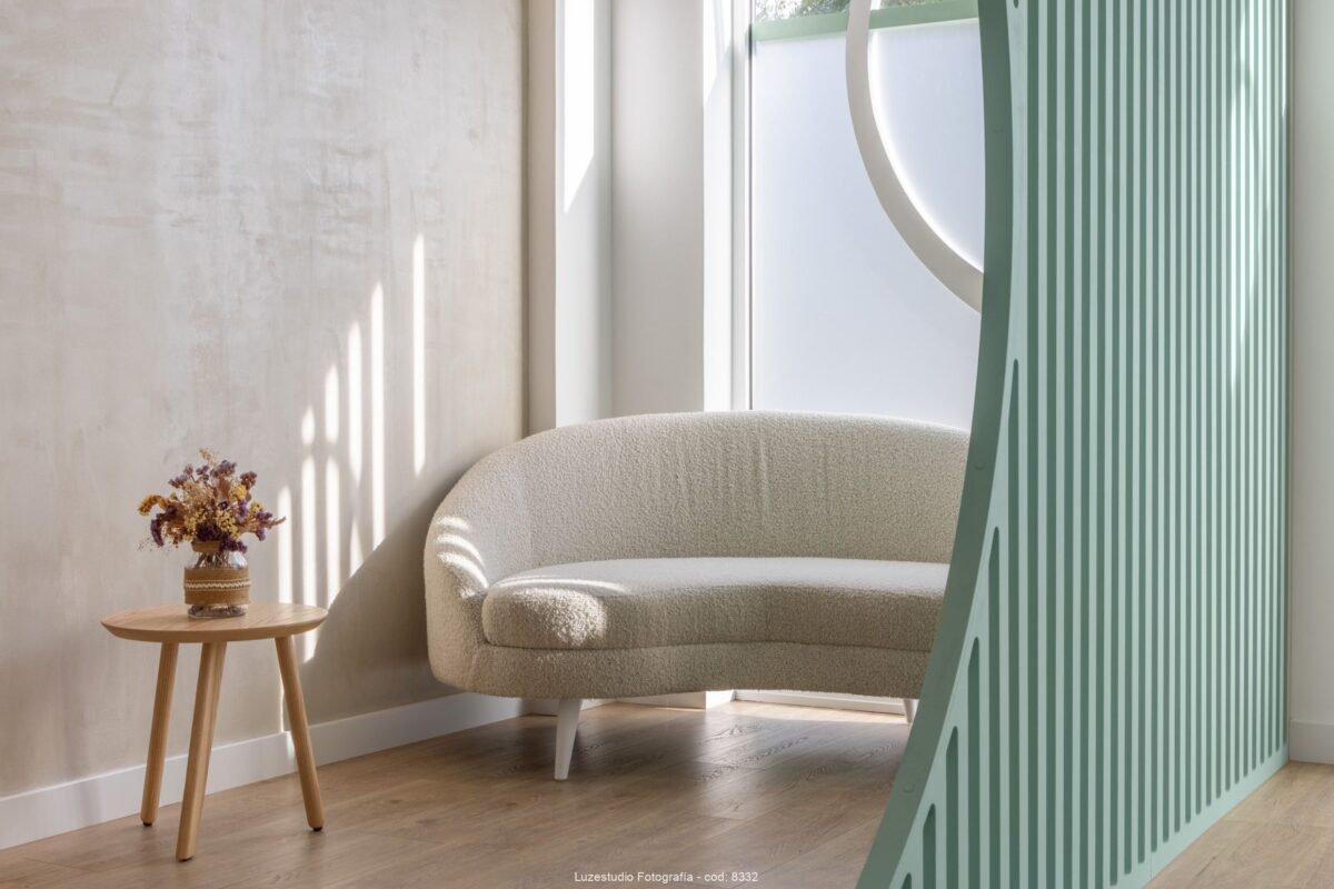 fotografía de interior espacio con luz natural y sofa tendencia 2023 con mesita redonda de madera y flores secas