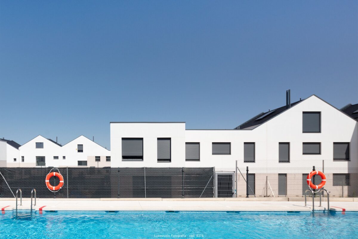 chalets pareados de una y dos plantas con persianas cerradas delante de piscina fotografía de proyectos residenciales realizada por alina banta