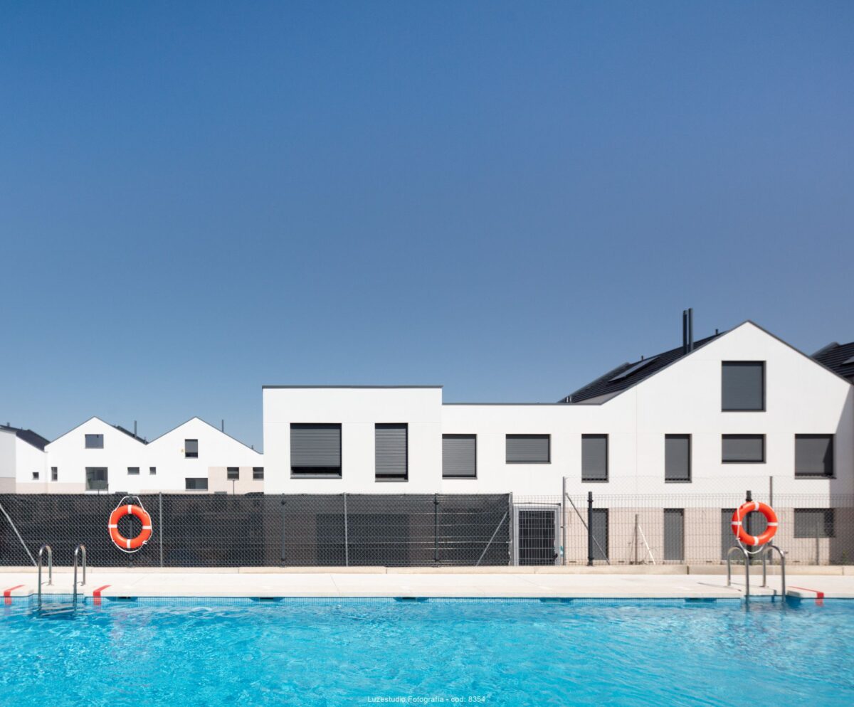 viviendas con fachadas blancas con piscina delante y cielo azul fotografiado en villalbilla por fotografo de arquitectura