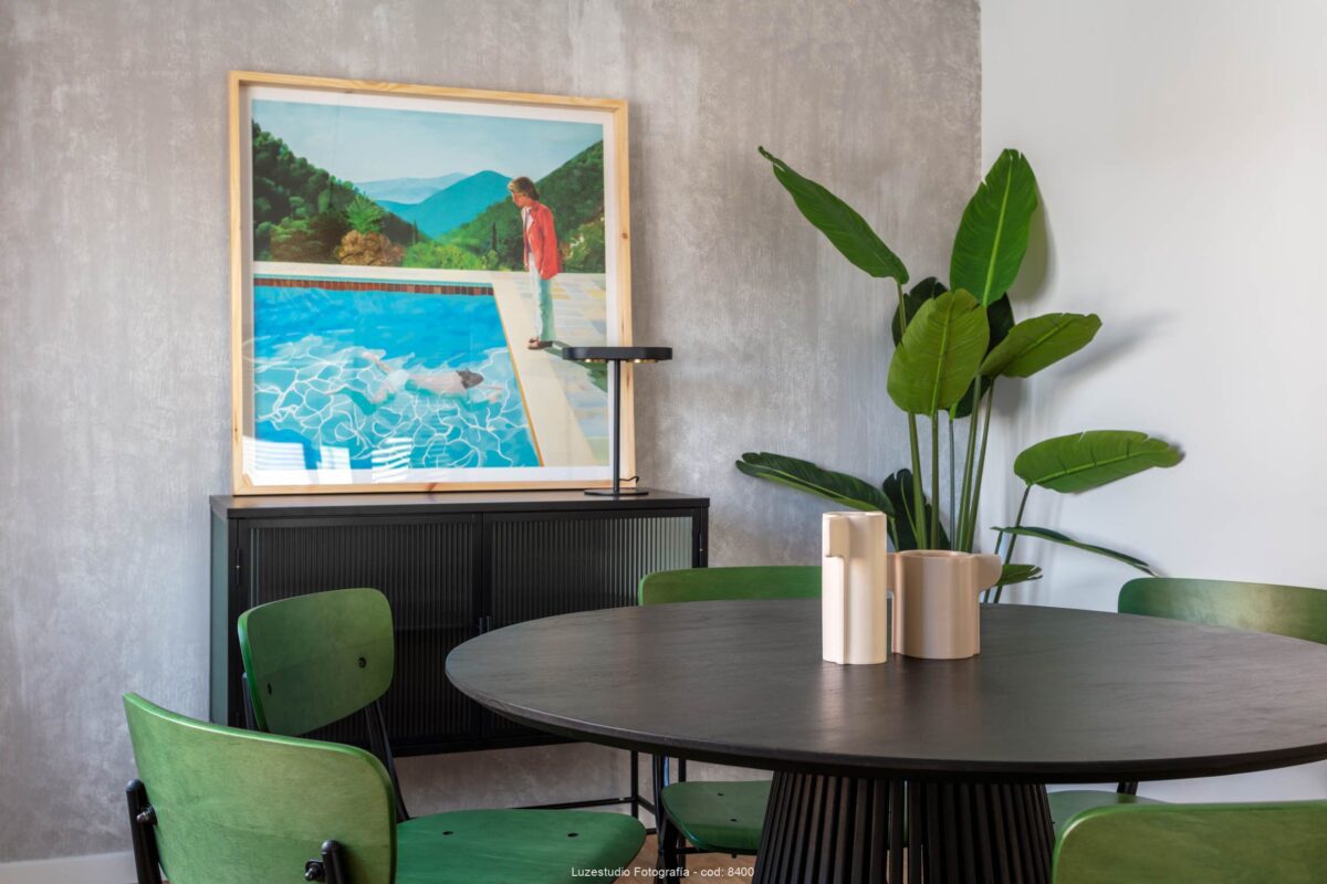 mesa redornda de kave home con cuadro decorativo en sala de reuniones con pared de hormigón decorativo