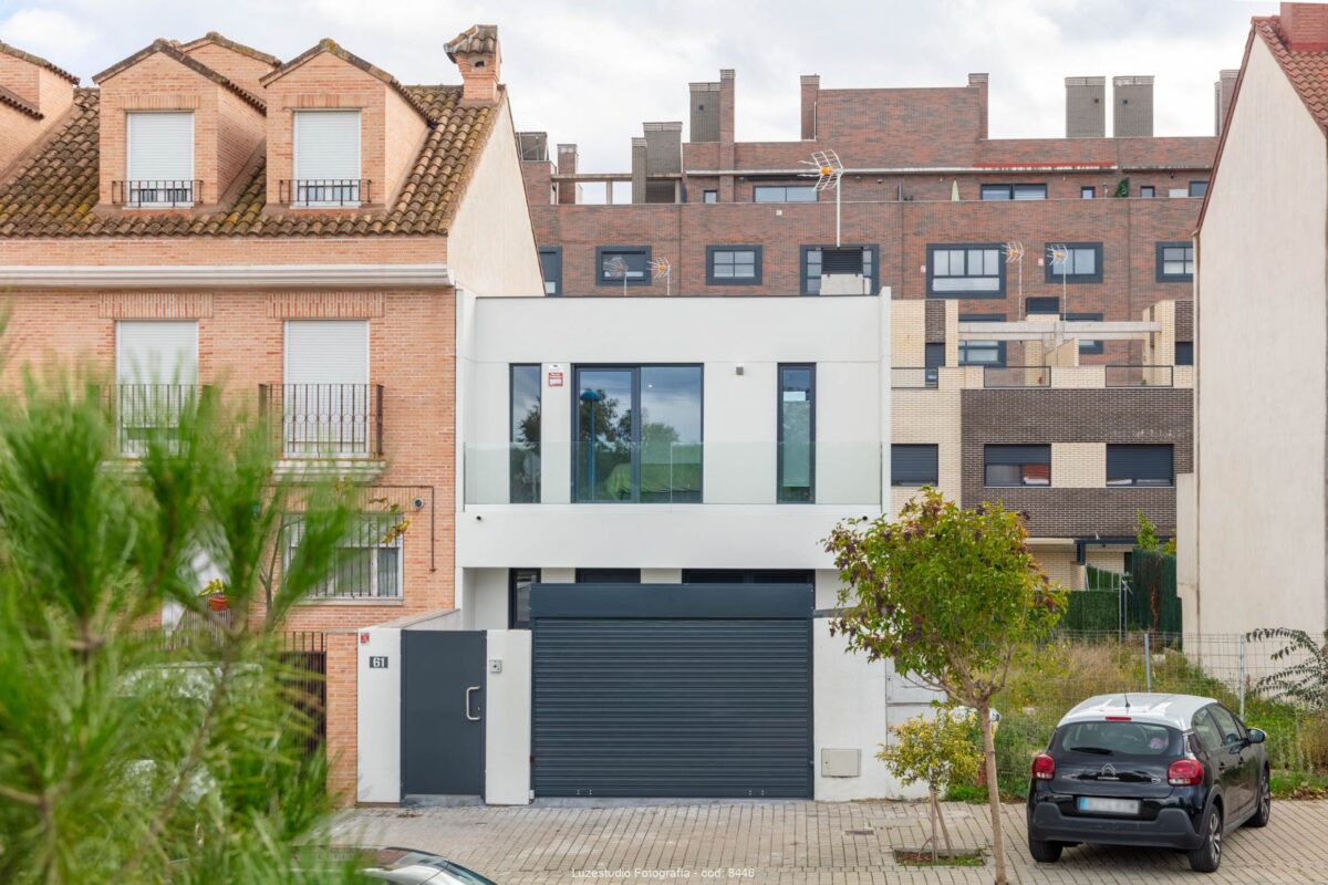 fachada principal de casa modular de una planta con viviendas alrededor