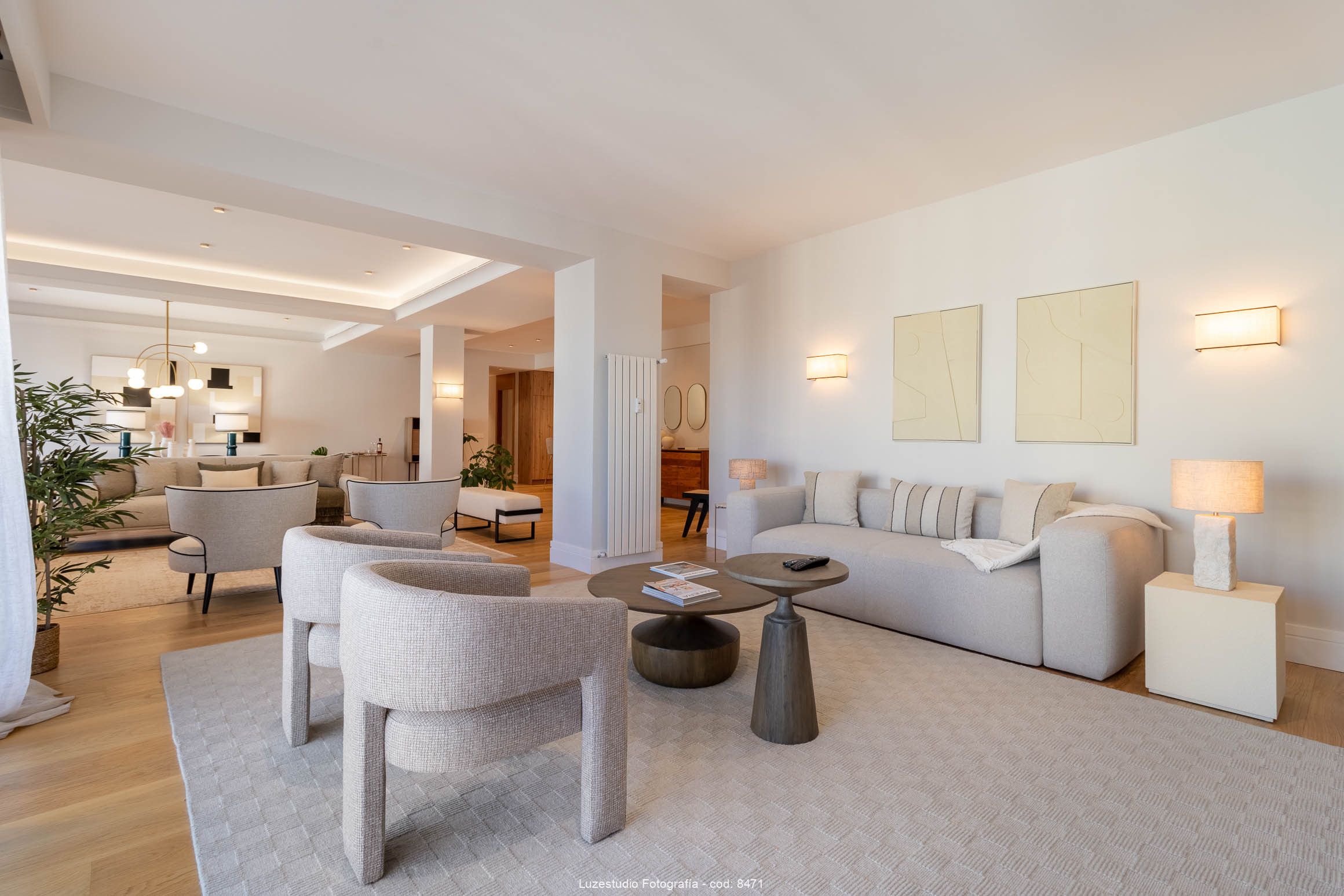 salón con sofa y butacas grises en piso con diseño de interiores minimalista con lamparas encendidas en reportaje fotografía de interiores
