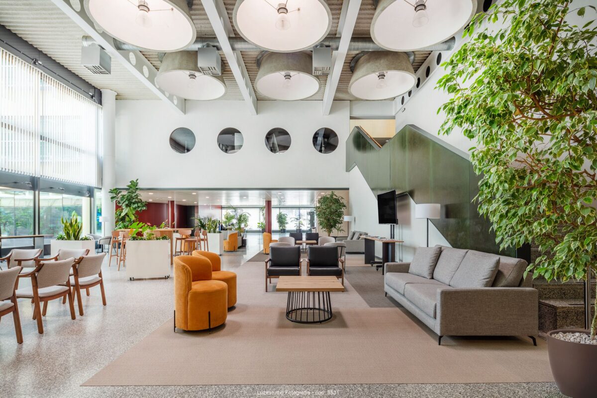 fotografía de interior zona de espera ayuntamiento con sofa mesas y sillas y techos altos