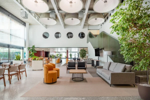 fotografía de interior zona de espera ayuntamiento con sofa mesas y sillas y techos altos