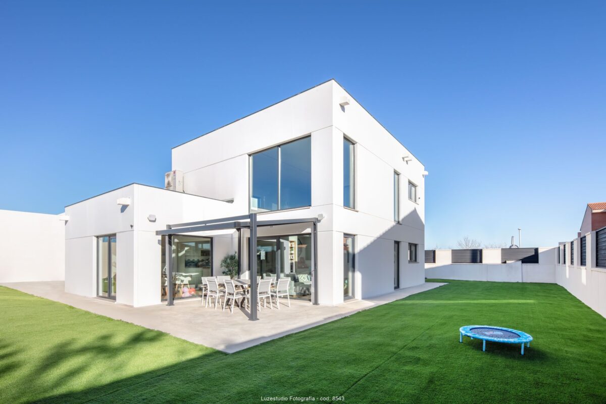 casa modular de una planta con terraza y patio con cesped artificial