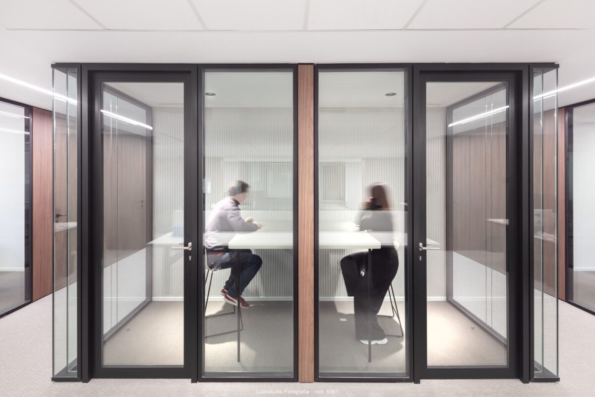 dos personas trabajando en cabinas insonorizadas en oficina de madrid