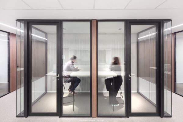 dos personas trabajando en cabinas insonorizadas en oficina de madrid