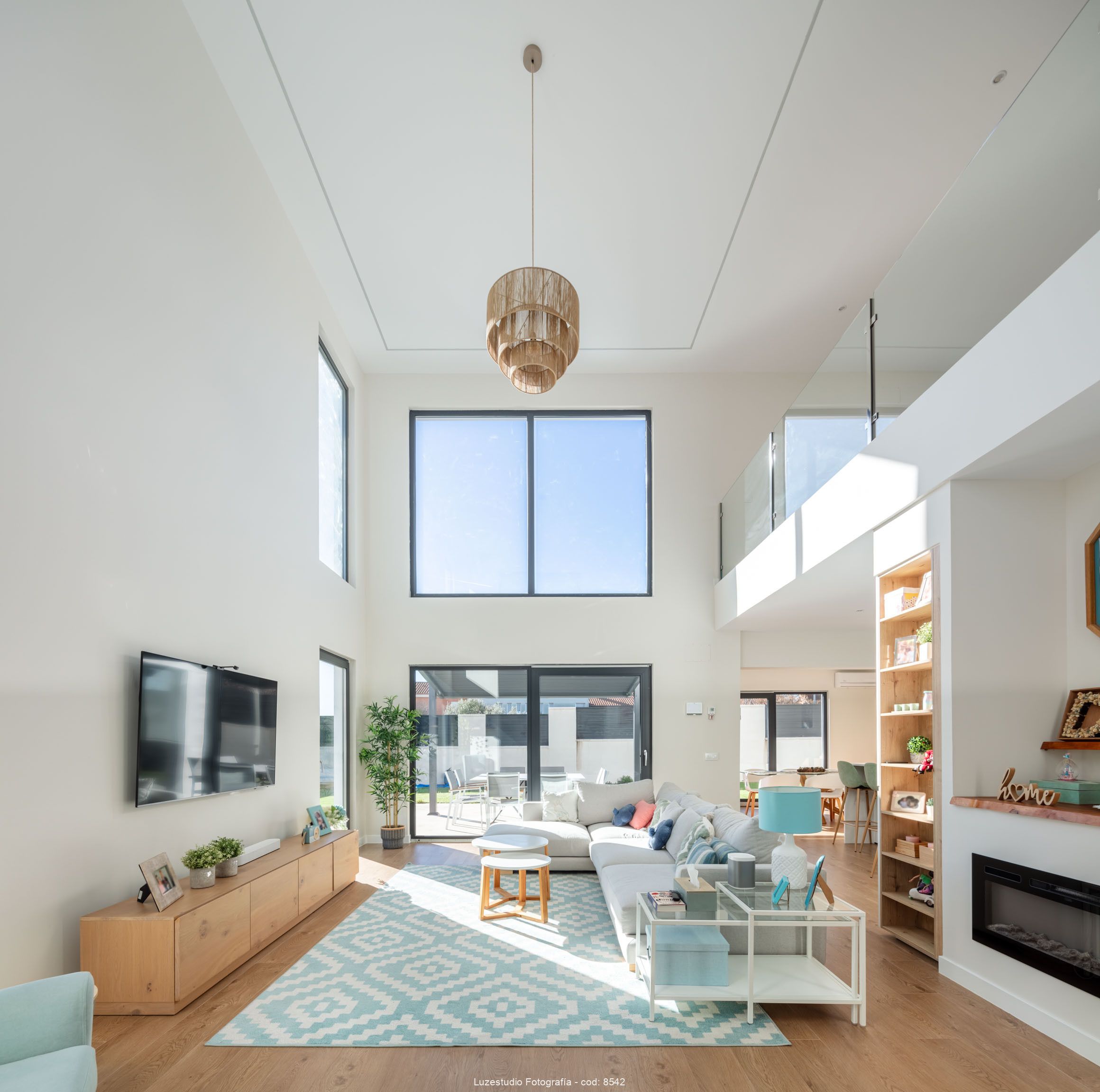 salón de doble altura con doble ventanal y mucha luz natural en el interior de casa modular