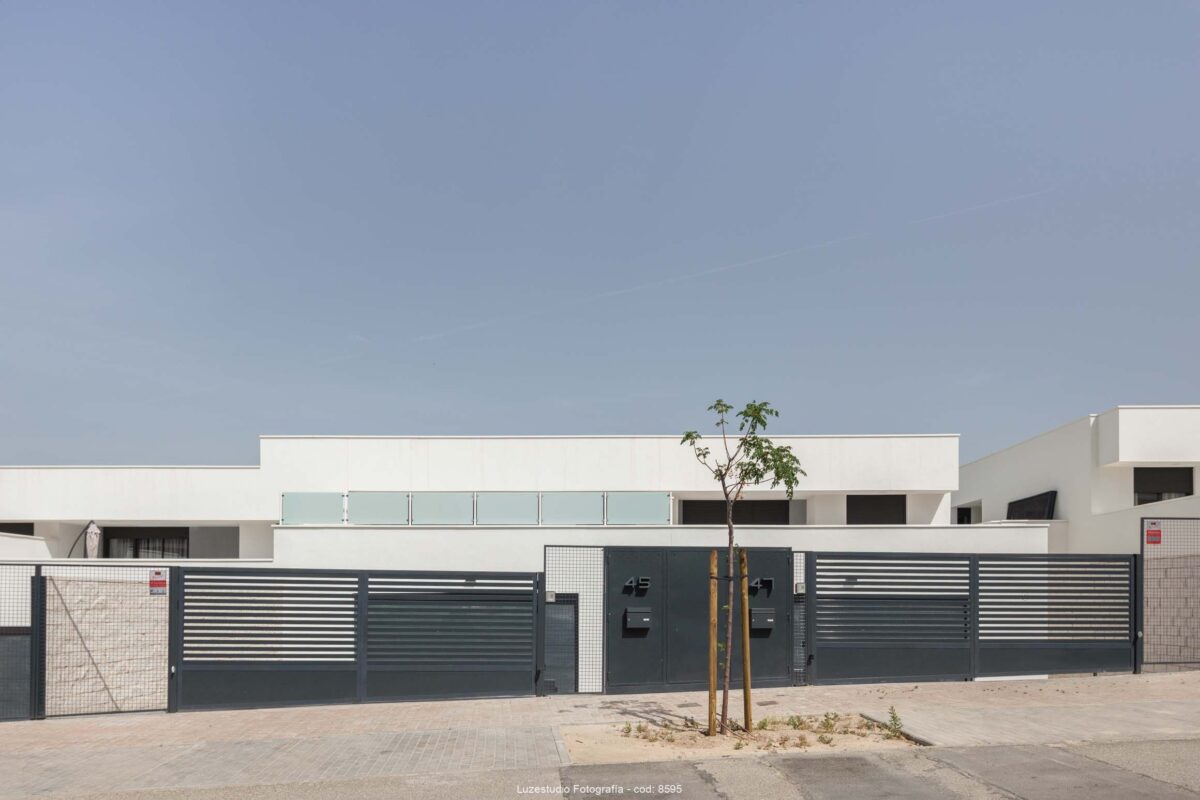viviendas pareadas de poca altura con puertas de entrada y arbol plantado delante