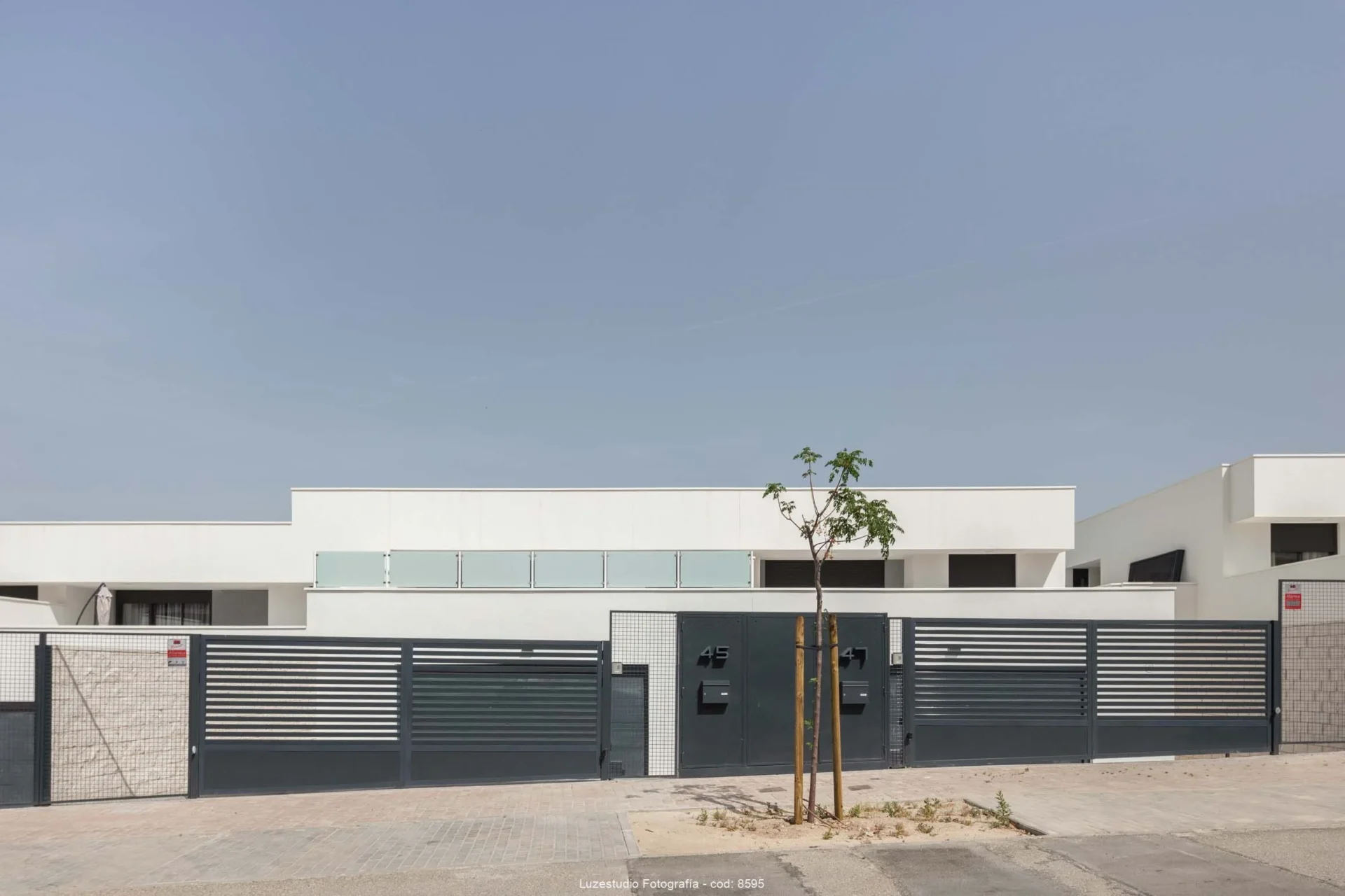 viviendas pareadas de poca altura con puertas de entrada y arbol plantado delante