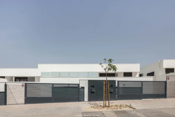 viviendas pareadas de poca altura con puertas de entrada y arbol plantado delante