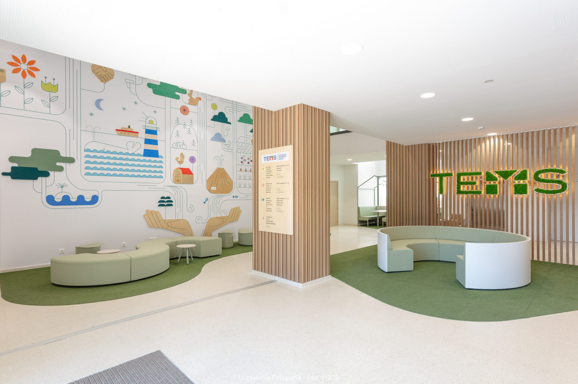 recepción de escuela montessori con sofás circulares madera decorativa e ilustraciones
