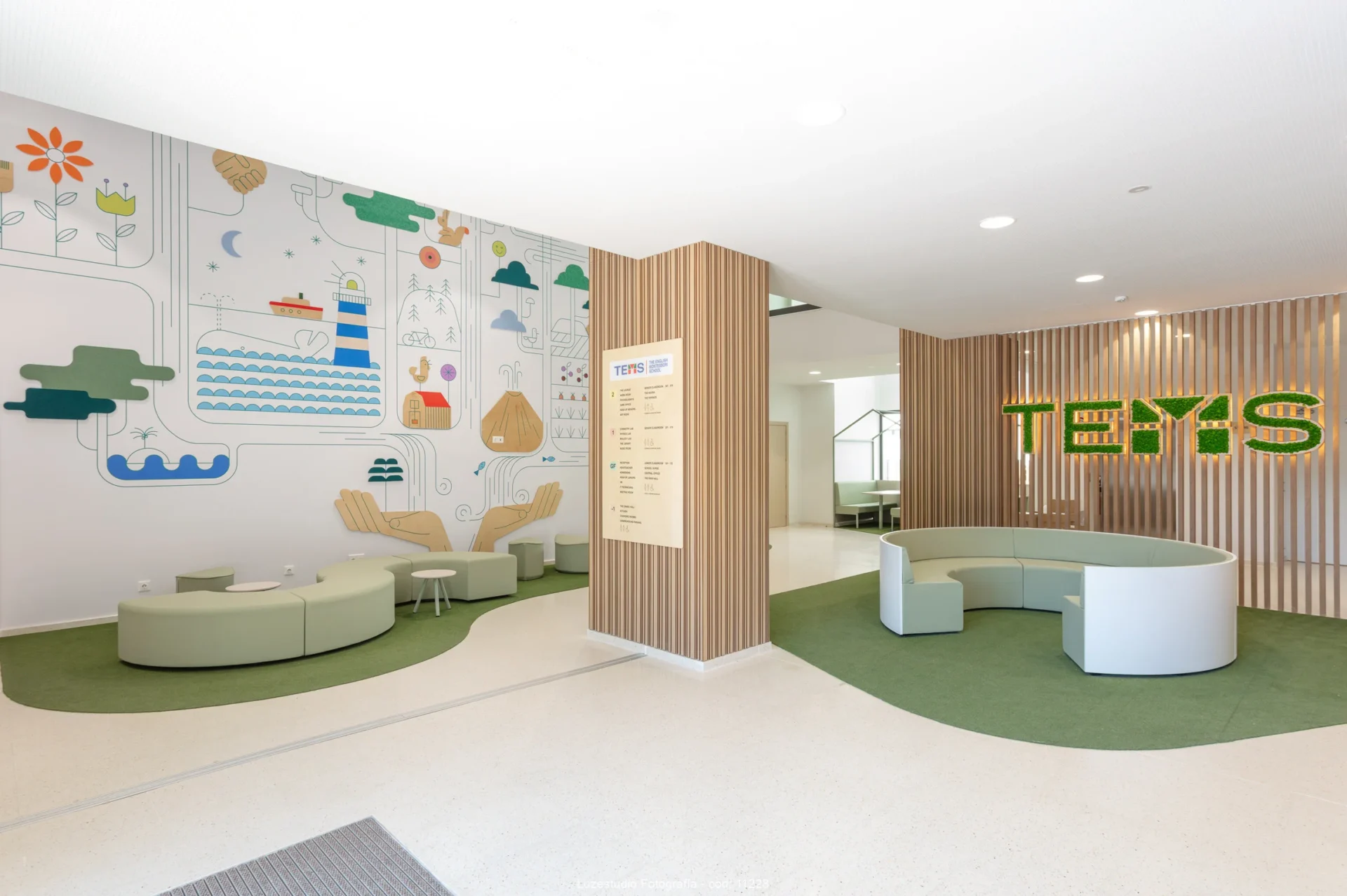 recepción de escuela montessori con sofás circulares madera decorativa e ilustraciones