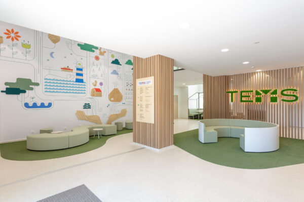 recepción de escuela montessori con sofás circulares madera decorativa e ilustraciones