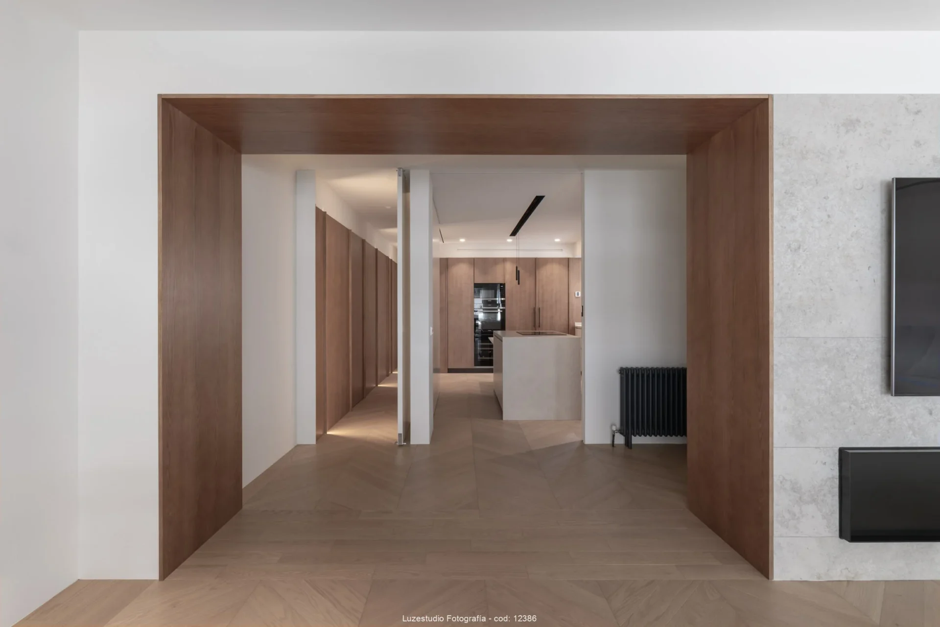 vista hacía cocina y pasillo desde vano de acceso revestido en madera.