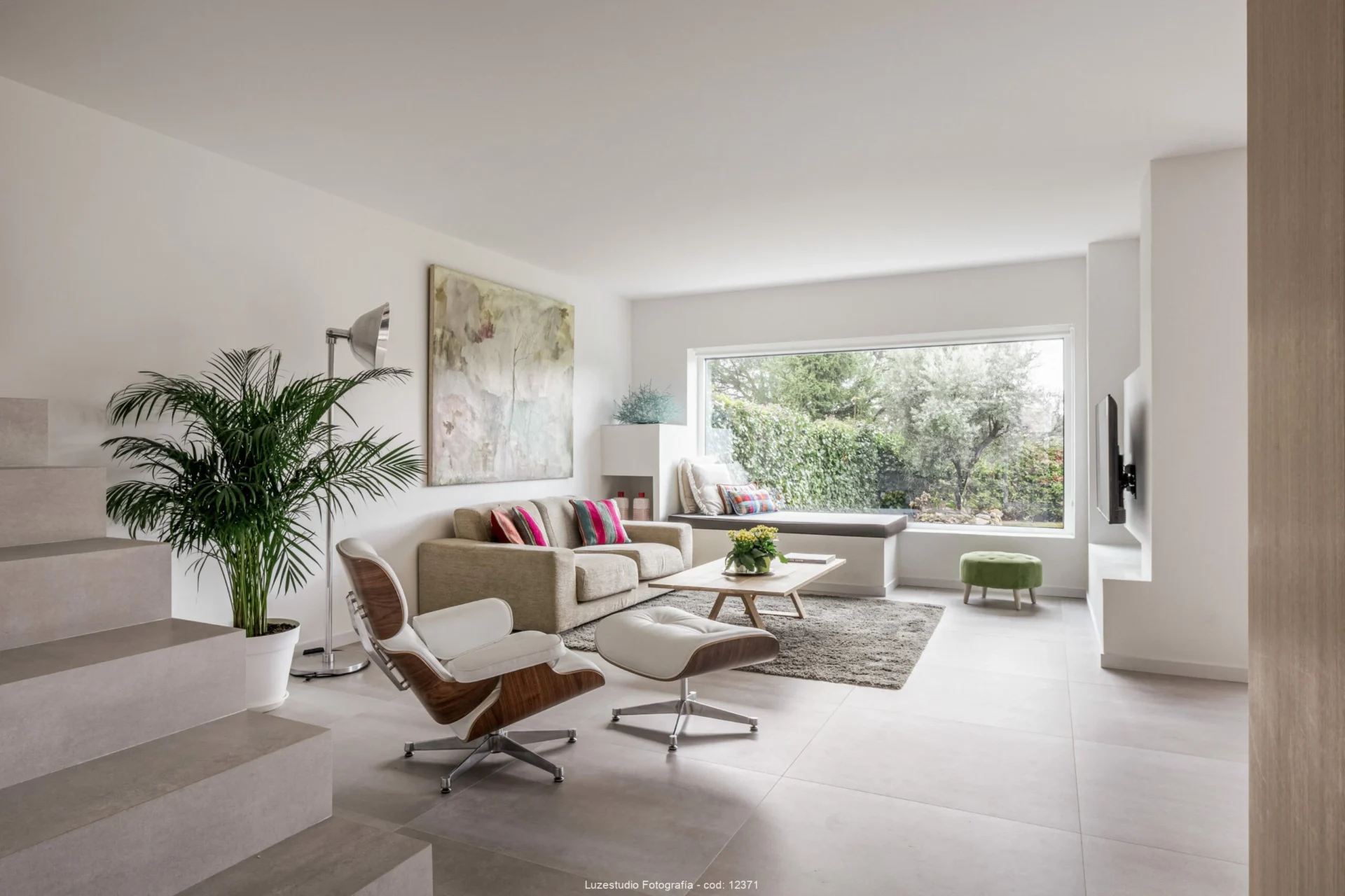 salón con sofa y chaise longue en casa con gran ventanal hacía el jardín